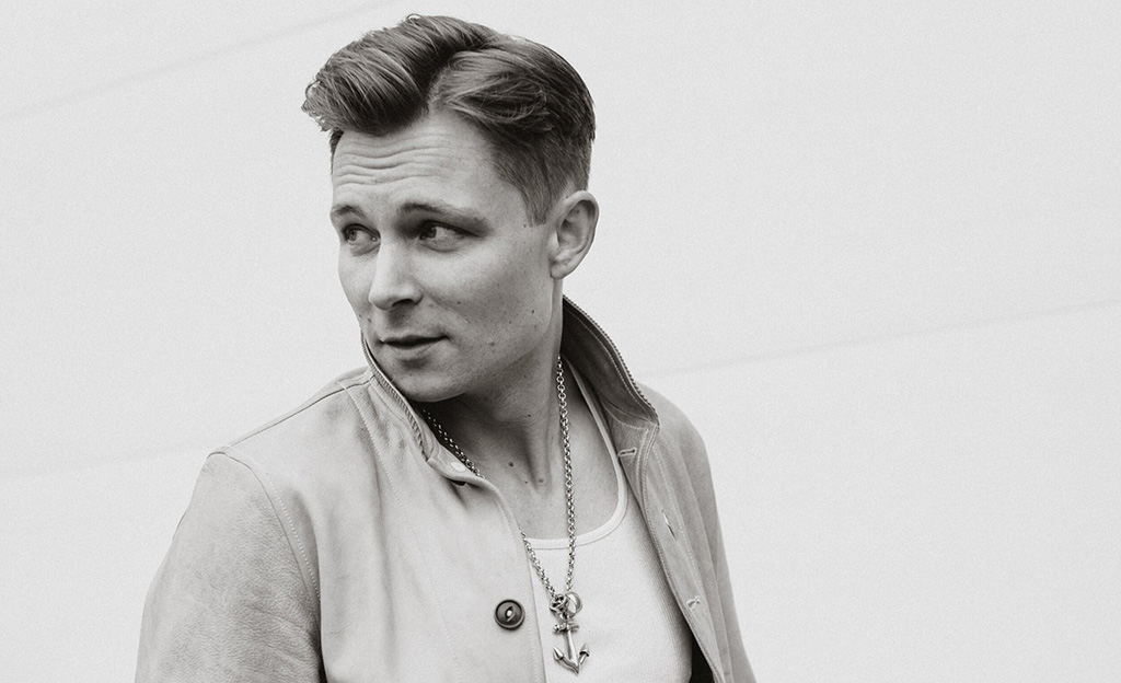 A black and white photo of Frankie Ballard looking to his left with a white background.