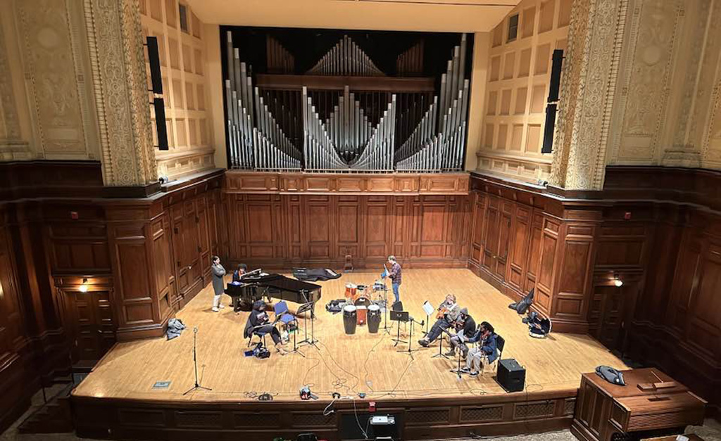 Latin American Ensemble onstage at a recital hall preparing for a performance.