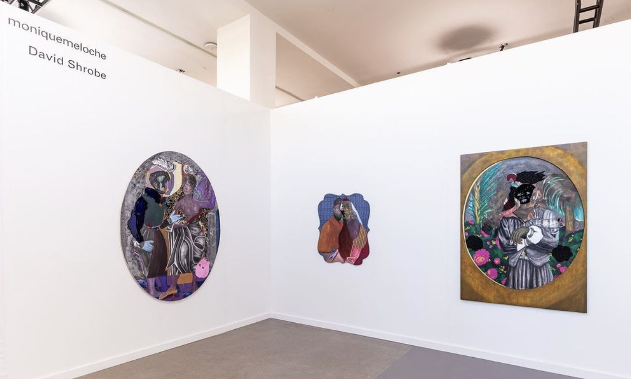 An installation image of David Shrobe's wall-hung artwork. Three wall-hung pieces are exhibited by Monique Meloche Gallery. Two are on the right wall and one is on the left. They are colorful and feature Black figures.  