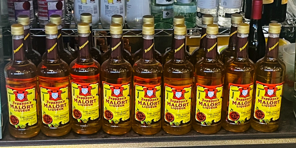 A row of Malört liquor bottles on a shelf as an image to promote Malört Fest in Champaign, Illinois. Photo by Lauren Kuleck.