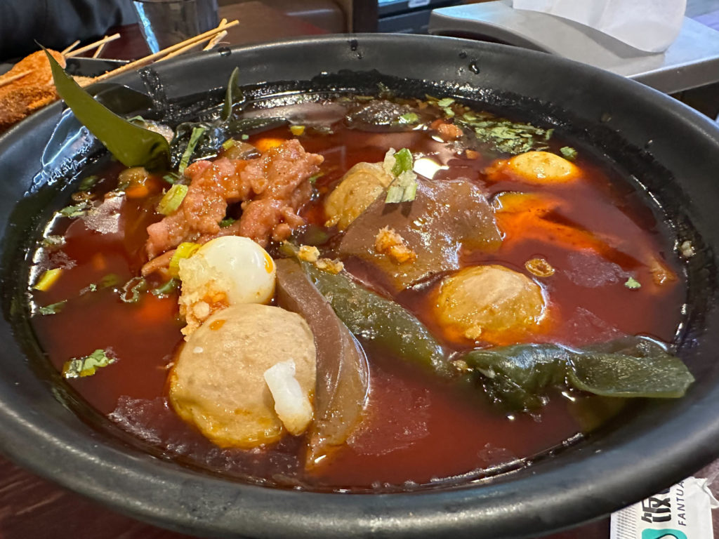 A spicy soup with lots of vegetables at Savory Hot Pot. Photo by Xiaohui Zhang.