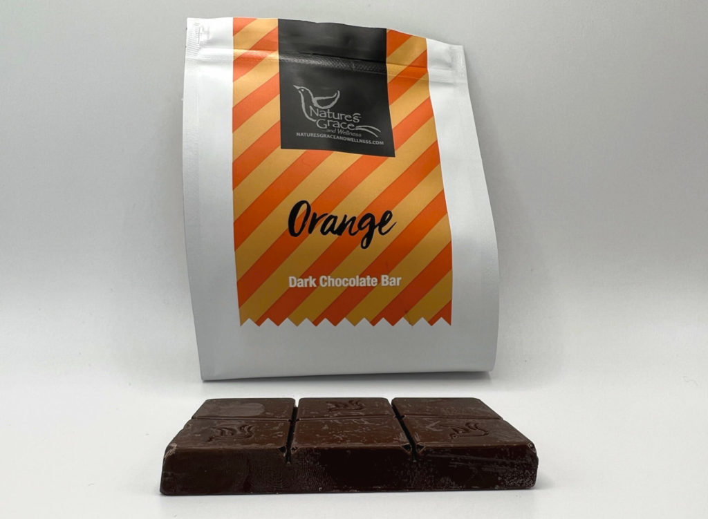 A block of chocolate with orange flavor and infused with cannabis is on a white counter in front of the Nature's Grace bag. Photo by Alyssa Buckley.