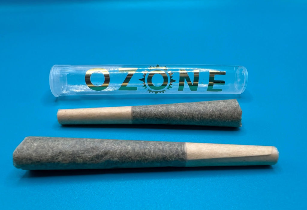 Two prerolls of cannabis by Ozone are on a blue counter with a blue backdrop for a list of 4/20 recommendations in Champaign-Urbana. Photo by Alyssa Buckley.