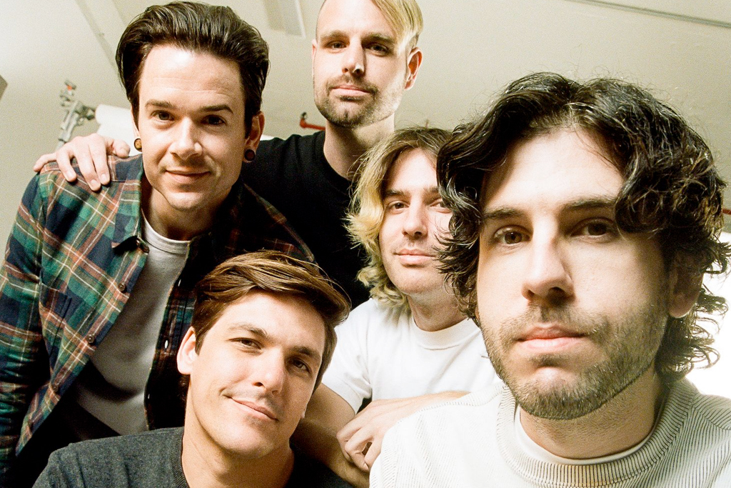 Five members of the band Real friends, in tight with each other and close to the camera.