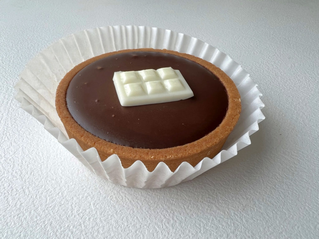 A chocolate tart with a white chocolate piece with six divets. Photo by Alyssa Buckley.