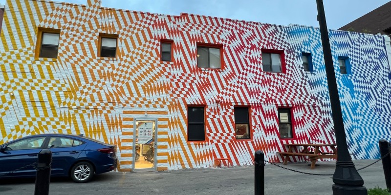 the side of a building is painted in yellow, red, and blue zig zag patterns