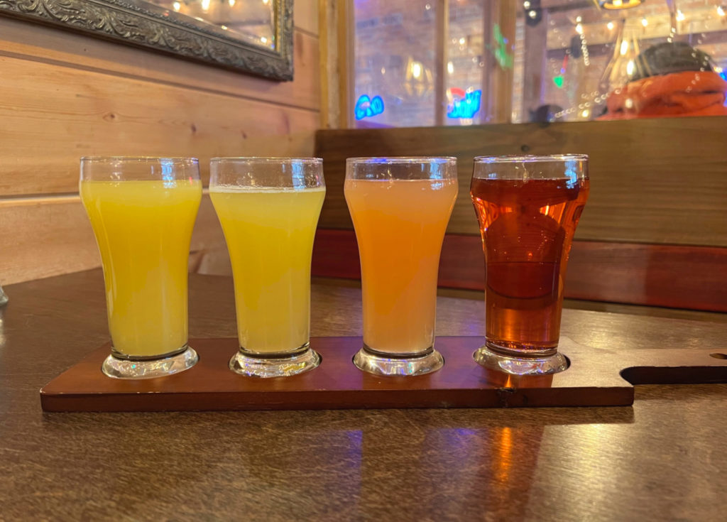 There are four mimosas on a wooden paddle tray at Cowboy Monkey brunch. Photo by Alyssa Buckley.