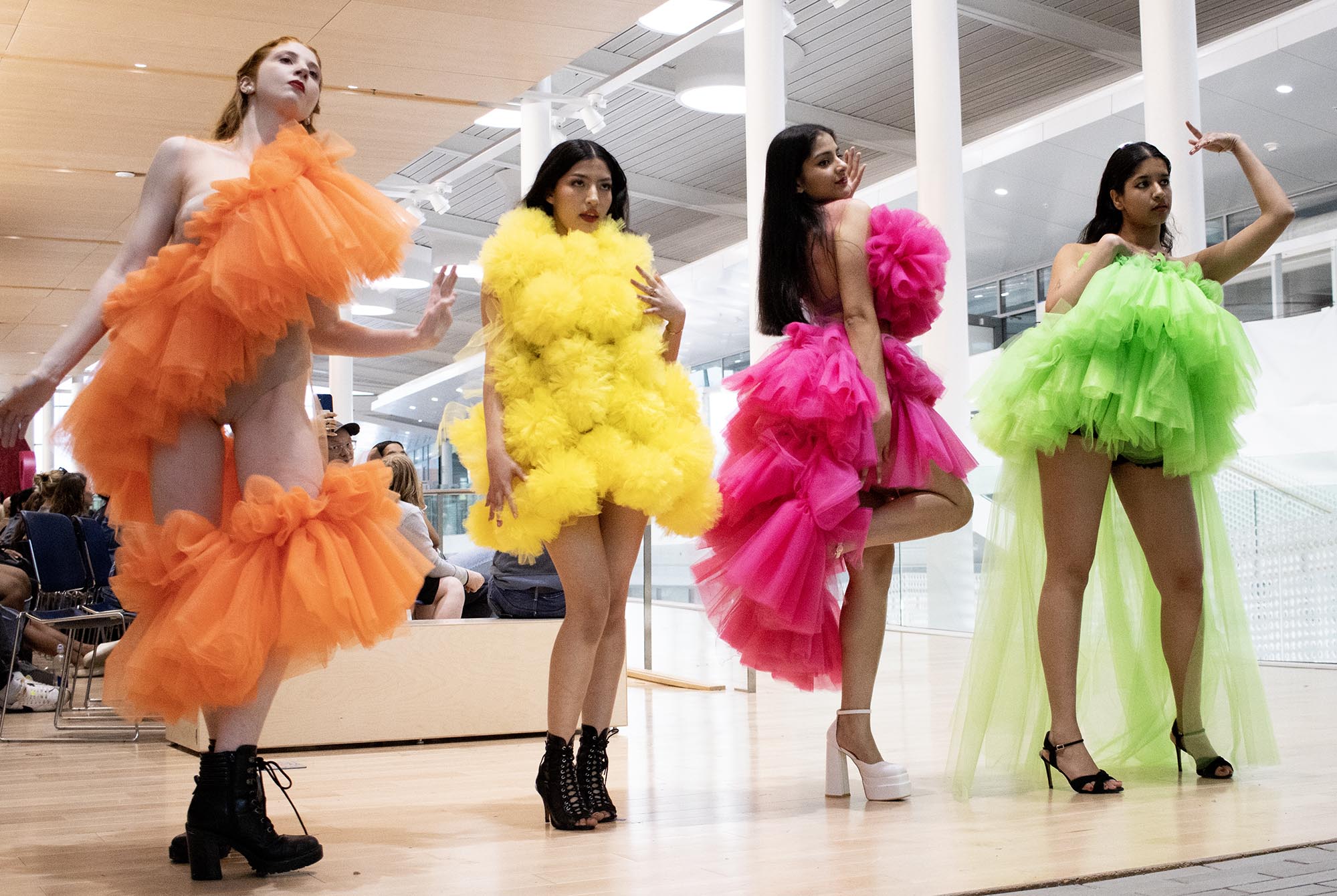 Re-Fashioned 2023, capstone collection from Miranda Mottlowitz. Models: Araditta Iyer, Sofia, Michaela Burrows, and Sharika. Each woman wears a different colored taffeta dress. One is orange, one is yellow, one is pink, and one is green.