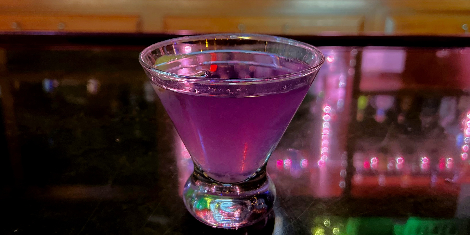 A purple cocktail is on the bar at Bentley's Pub in Downtown Champaign, Illinois. Photo by Alyssa Buckley.