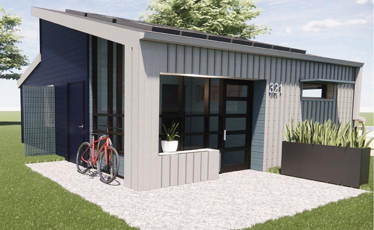 A mockup of a tiny home with light gray siding and a dark gray slanted roof. It has a small cement patio surrounded by grass.