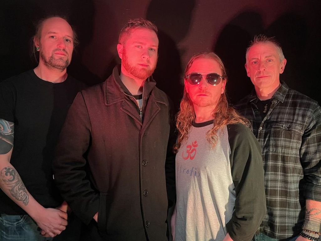 Four members of Astrofix lit up in red light against a dark background.