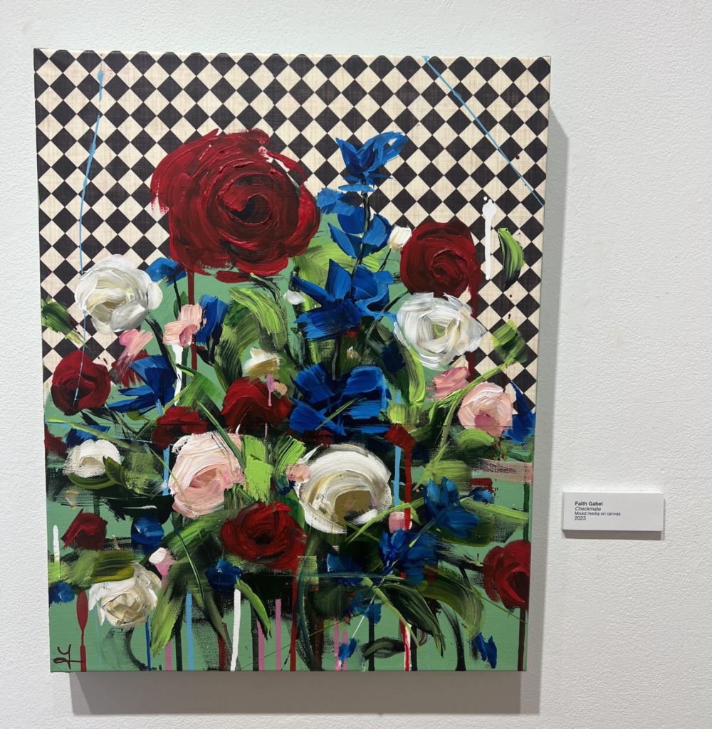 Vertical painting; bright red, blue, and white flowers take up most of the canvas with a black and white check background. 