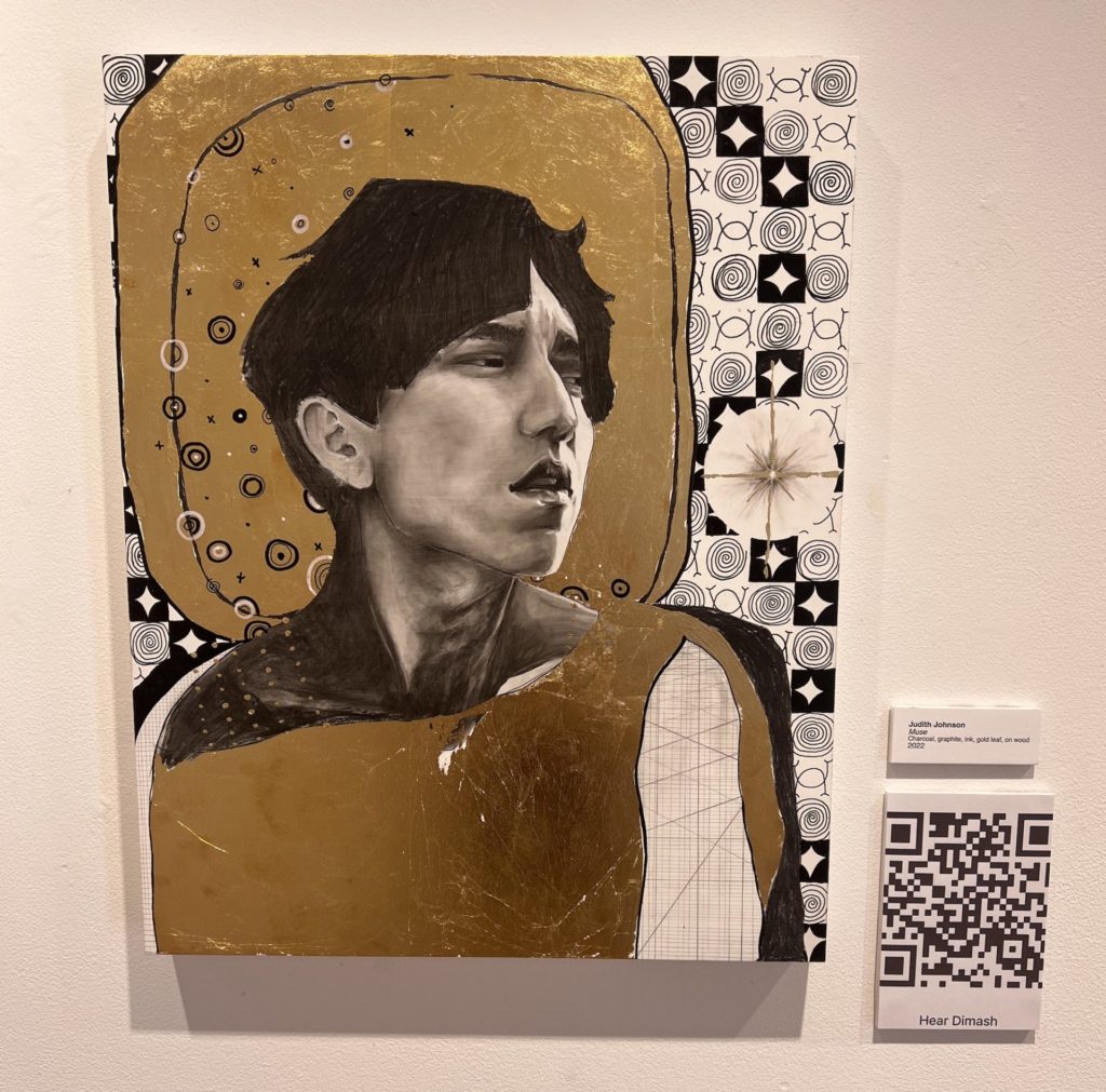 A black and white up close rendering of Dimash is laid on a gold silhouette. Abstract black and white swirls and line are along the right side of the work. 