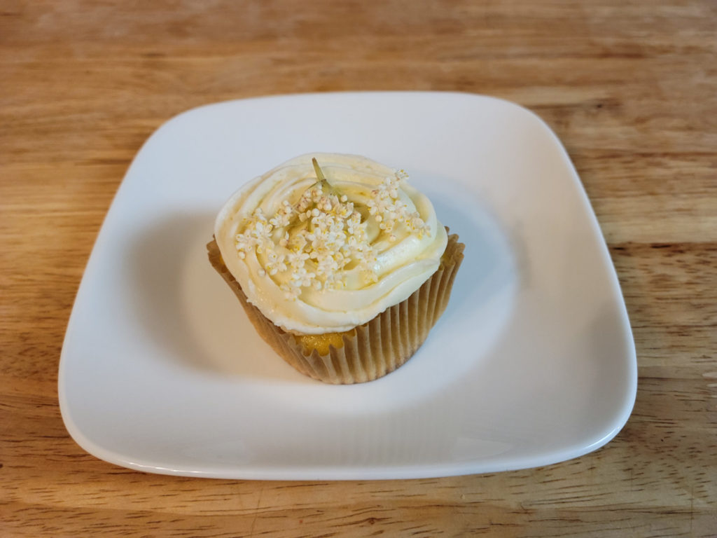 An elderflower salted lemon mini cake with a cupcake wrapper on a small plate. Photo by Matthew Macomber.