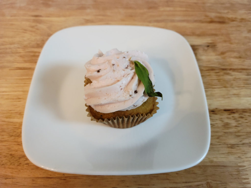 A pea, mint, and rose mini cake with a cupcake wrapper on a small plate. Photo by Matthew Macomber.