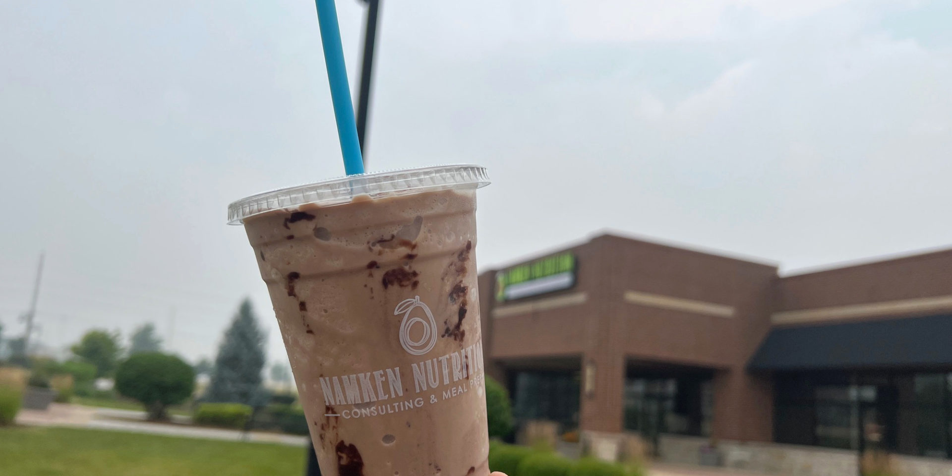 A cropped image of a chocolate smoothie in front of Namken Nutrition in Urbana. Photo by Alyssa Buckley.
