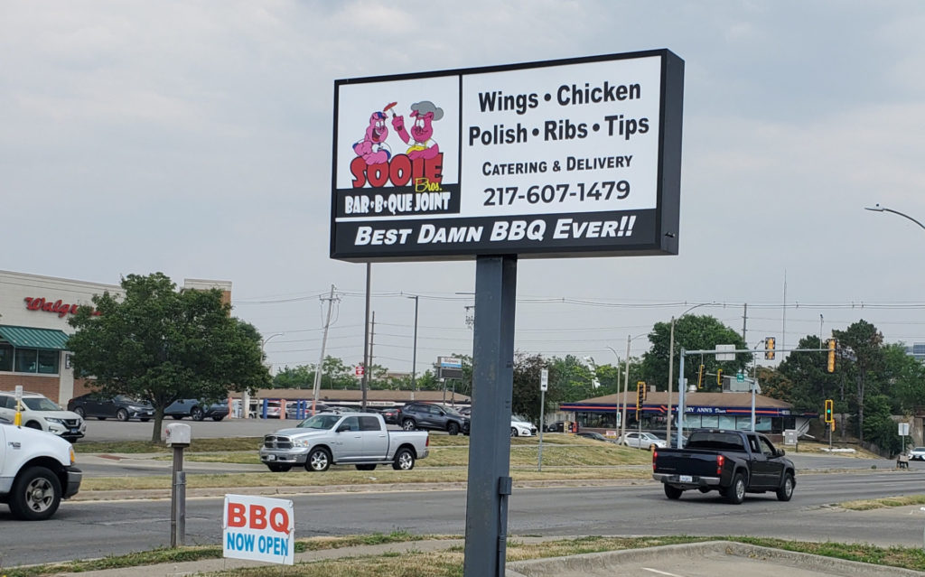 The sign outside of Sooie Bros Bar-B-Que Joint faces Kirby Avenue in Champaign, Illinois. Photo by Carl Busch.