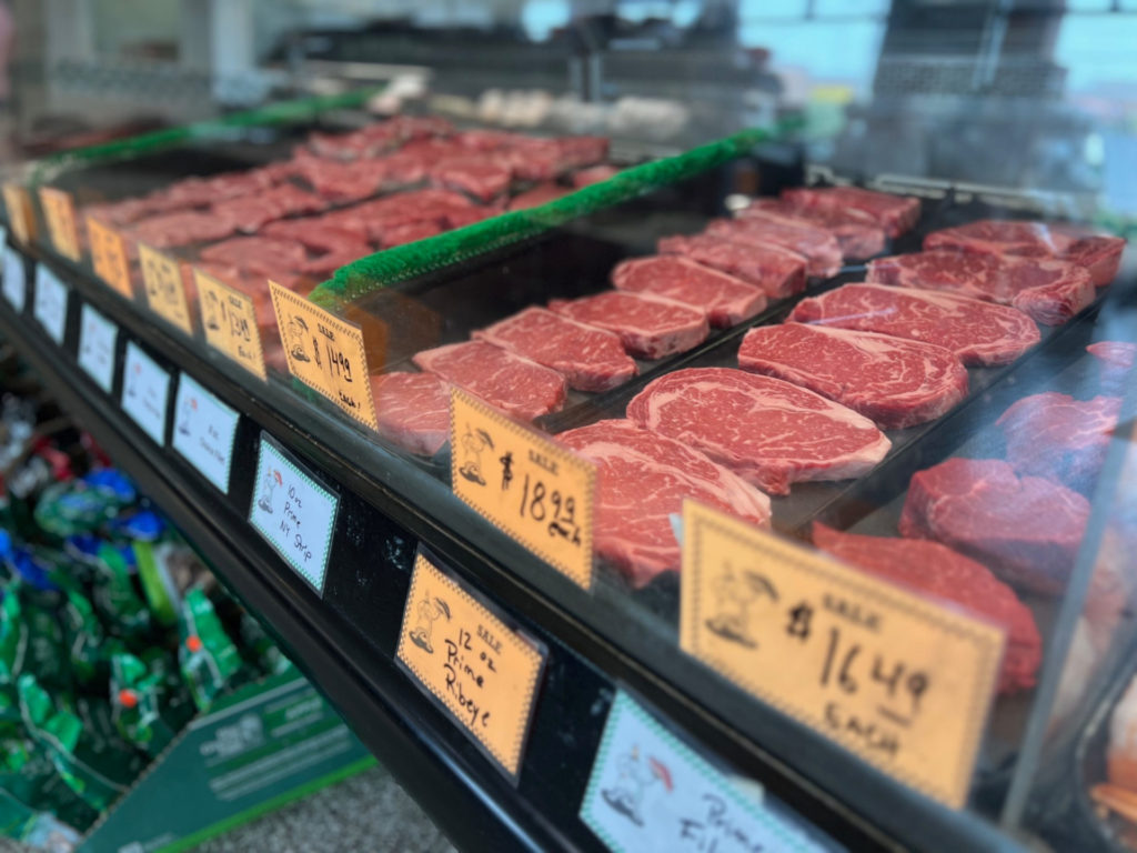 Several steaks are red in the case with orange sale prices. Photo by Alyssa Buckley.