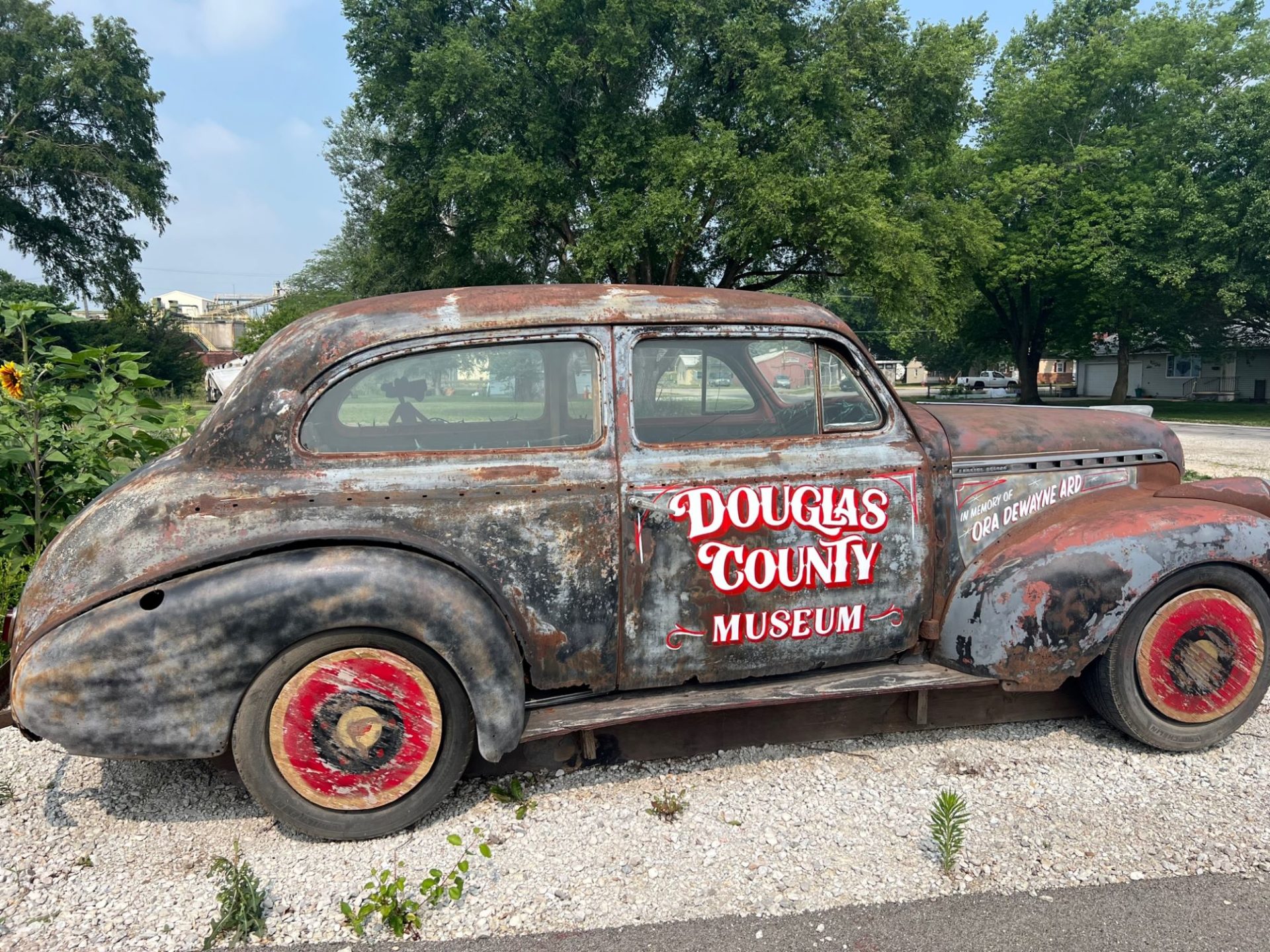 An old rusted car with Douglas County Museum painted in white and red lettering. 