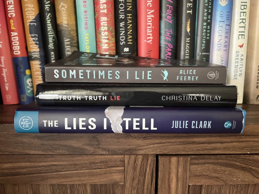 Truth Truth lie sits in a stack of books on a bookshelf along with "Sometimes I lie" and "The lies I tell"