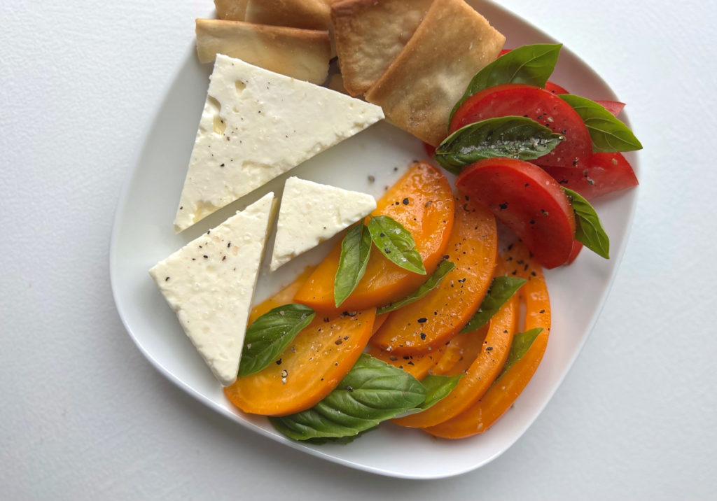 A photo of feta cheese, tomatoes, basil, and crackers in Champaign-Urbana. Photo by Alyssa Buckley.