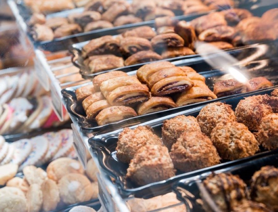 Close up of trays of pastries in a glass pastry case.