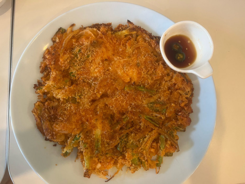 Kimchi pancake with fried batter, kimchee, squid, onions, and green onions. Photo by Grace Kang.
