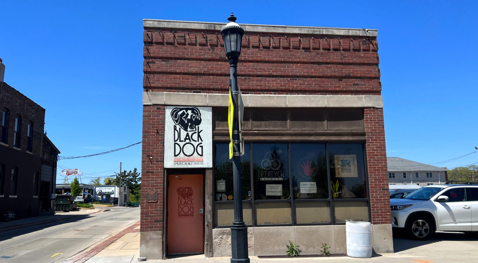 The exterior of Black Dog Urbana on a sunny day with a bright blue sky. Photo by Alyssa Buckley.
