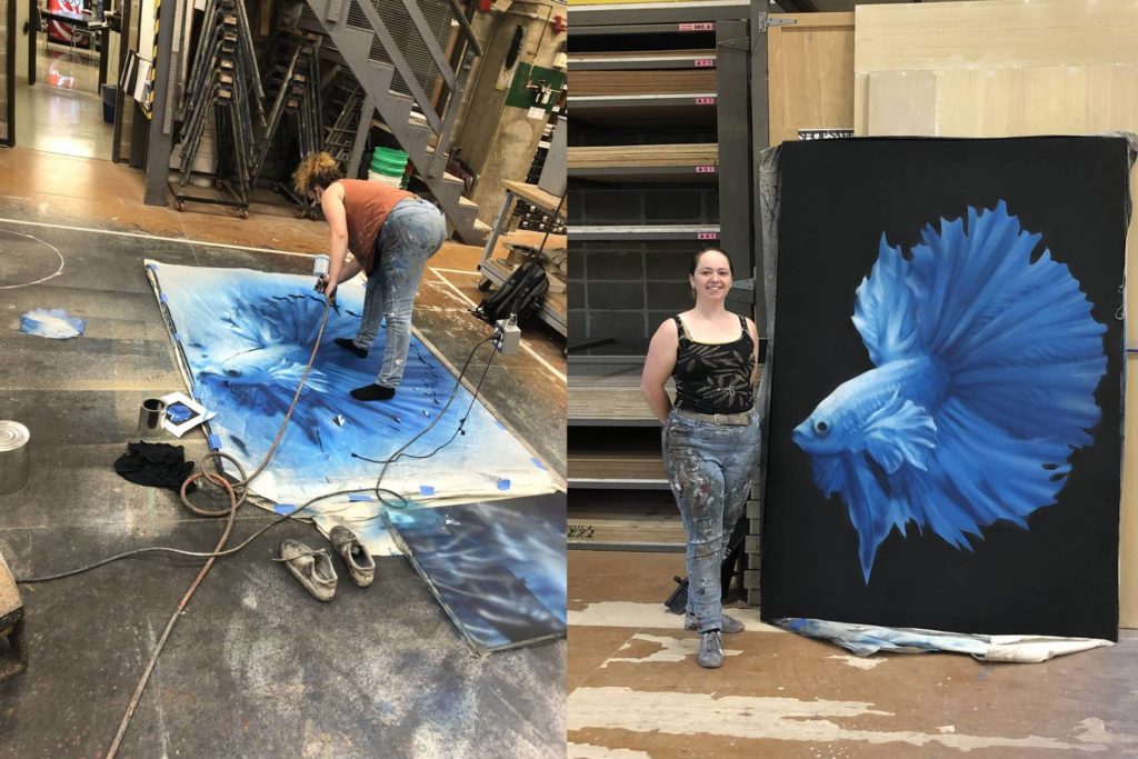 A two photo collage showing a student painting a large canvas and on the right standing next to the completed canvas: a black background with a huge beautiful blue fish. The canvas is larger than the painter. 