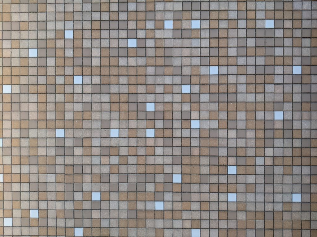 A close up shot of a tile wall in shades of brown, tan, and white.