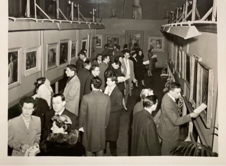 A large group of guests Guests viewing the paintings on display at the 1948 Festival of 
Contemporary American Arts ; a black and white photo
