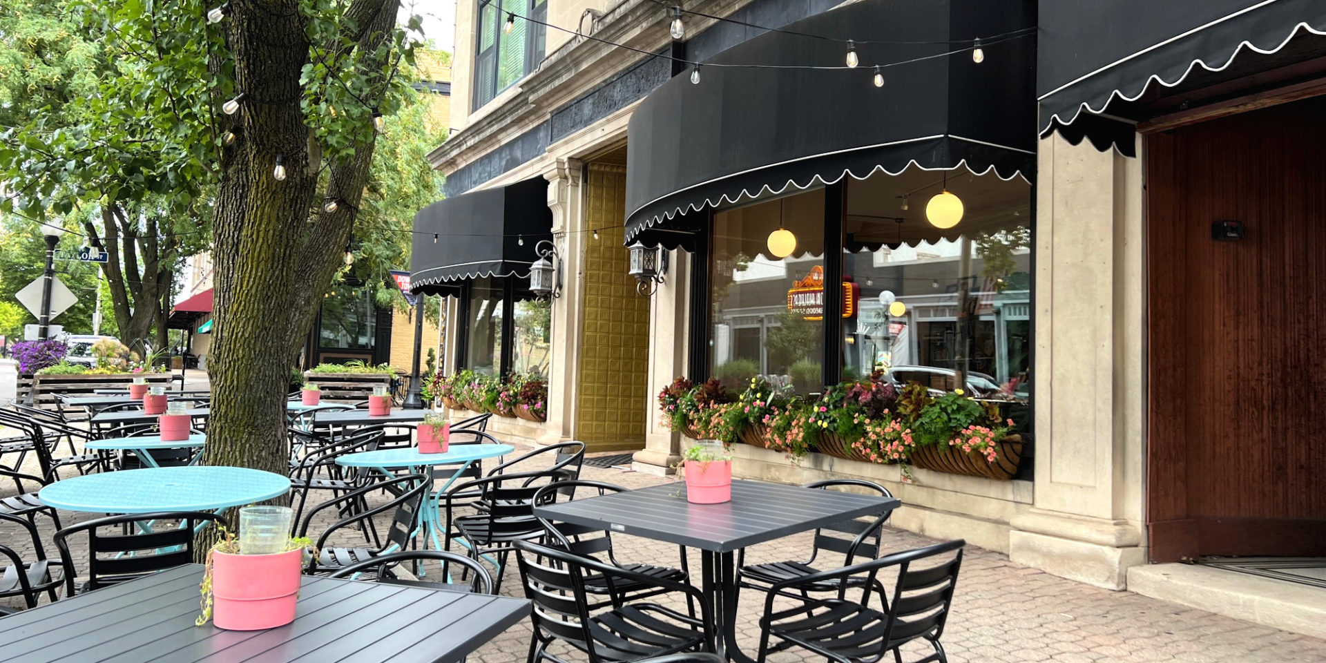 The Literary Cafe in Downtown Champaign has a black awning and tables outside on the sidewalk. Photo by Alyssa Buckley.