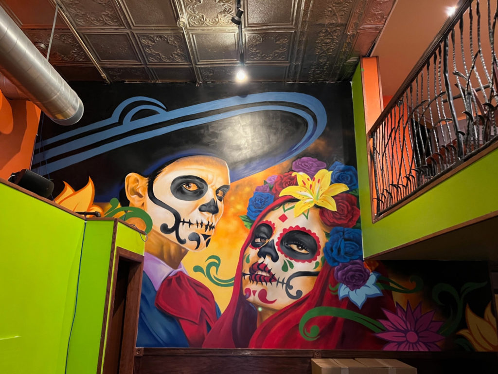 Inside Encanto Restaurant and Bar, there is a mural of two Mexican dancers in makeup. Photo by Alyssa Buckley.