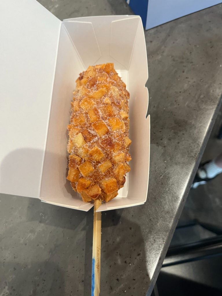 A photo of a corndog with diced potato in the fried batter. Photo by Ayesha Mehta.