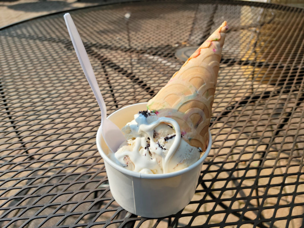 Mint chocolate chip and cookies and cream ice cream drizzled with marshmallow syrup in a cup with a birthday cake waffle cone stuck into the ice cream. Photo by Matthew Macomber.