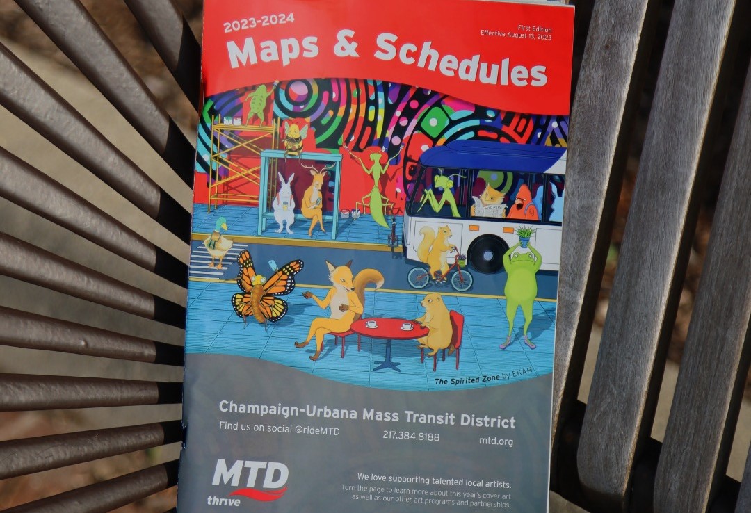 A booklet with artwork depicting various animals riding on or waiting for a bus.