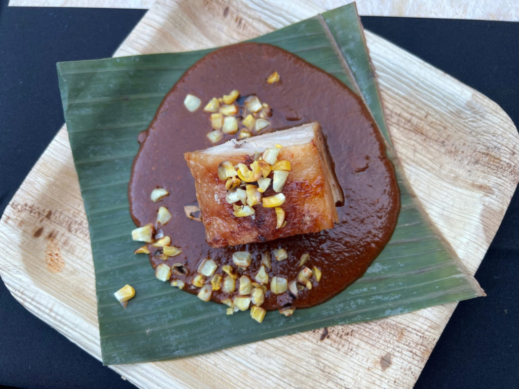 An overhead photo of the third course of Maize's tequila dinner: the pork belly on a mole sauce with charred corn kernels. Photo by Alyssa Buckley.