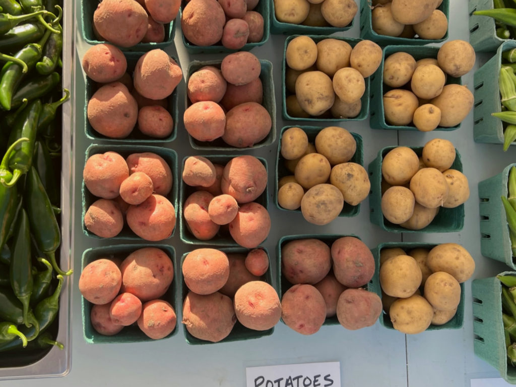 An overhead photo of potatoes for sale at the farmers' market. Photo by Alyssa Buckley.