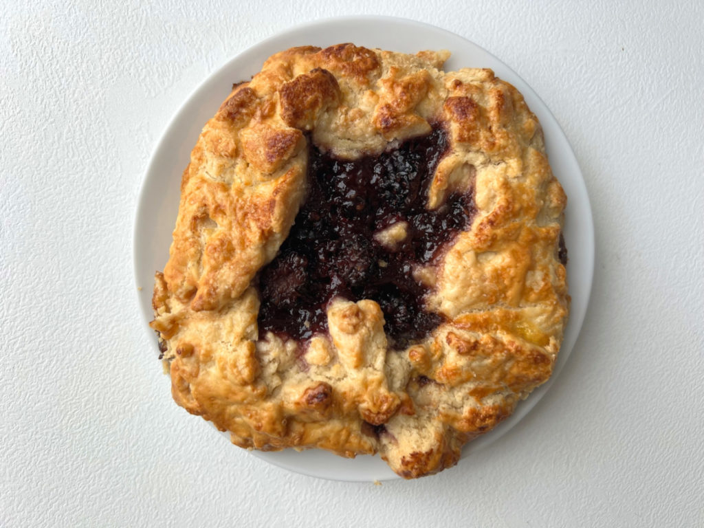 A close up of a buttery pastry with a blackberry center by Feel Good Flour, a home baker in Urbana, Illinois. Photo by Alyssa Buckley.