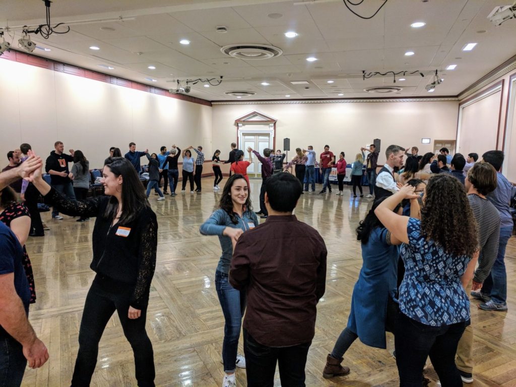 A large group of dancers learn to swing dance inside of the illini union 