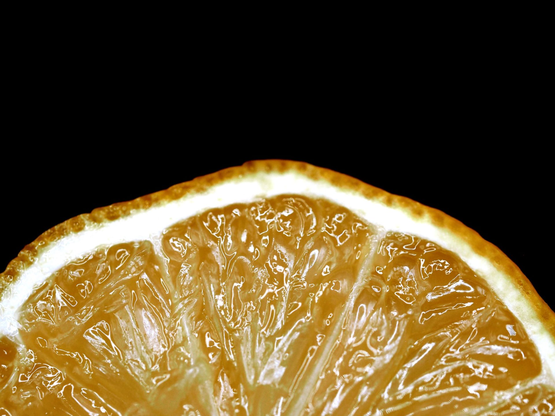 Close up of a small piece of a lemon against a black backdrop
