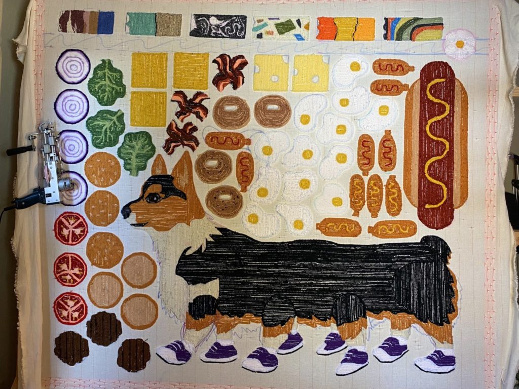 early stages of the rugs with everyone on one piece of fabric before being cut out. visible are hamburger components, a hot dog, and corgipillar