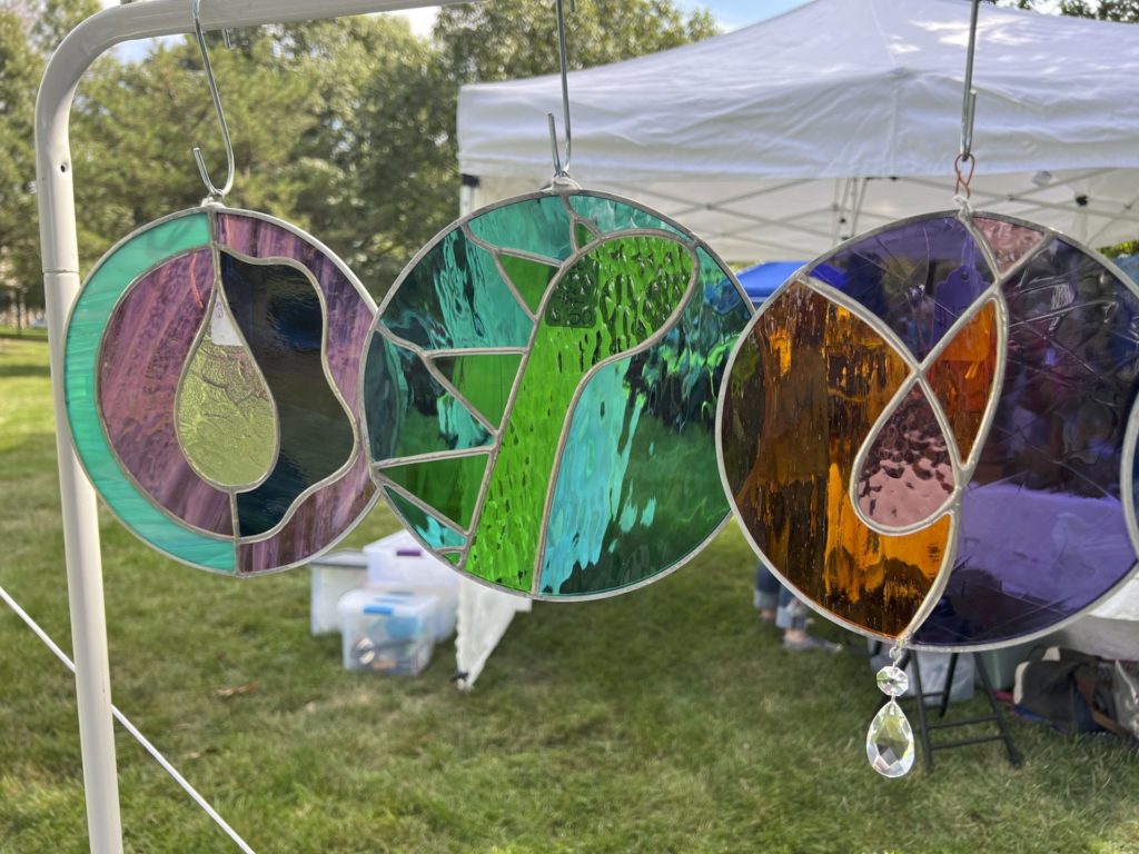 three round stained-glass pieces hang from the tent bar. 
