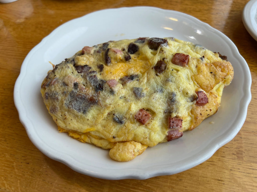 The oven-baked meat lovers omelette is filled with sausage, ham, bacon, and cheese and easily serves two.
