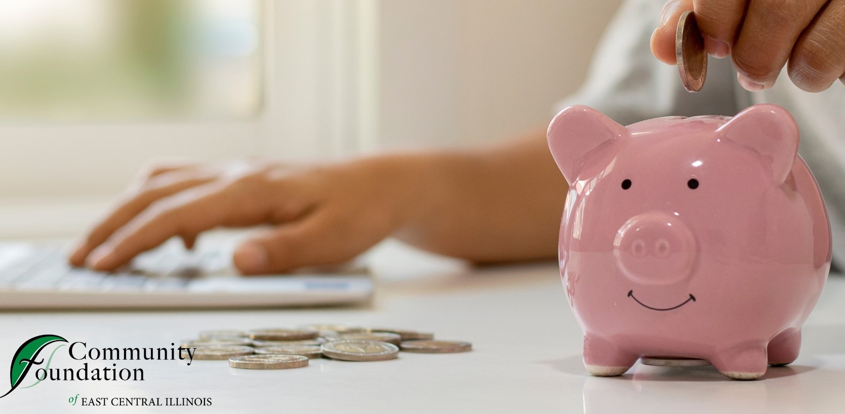 Close up of a person dropping change in to a pink piggy bank.