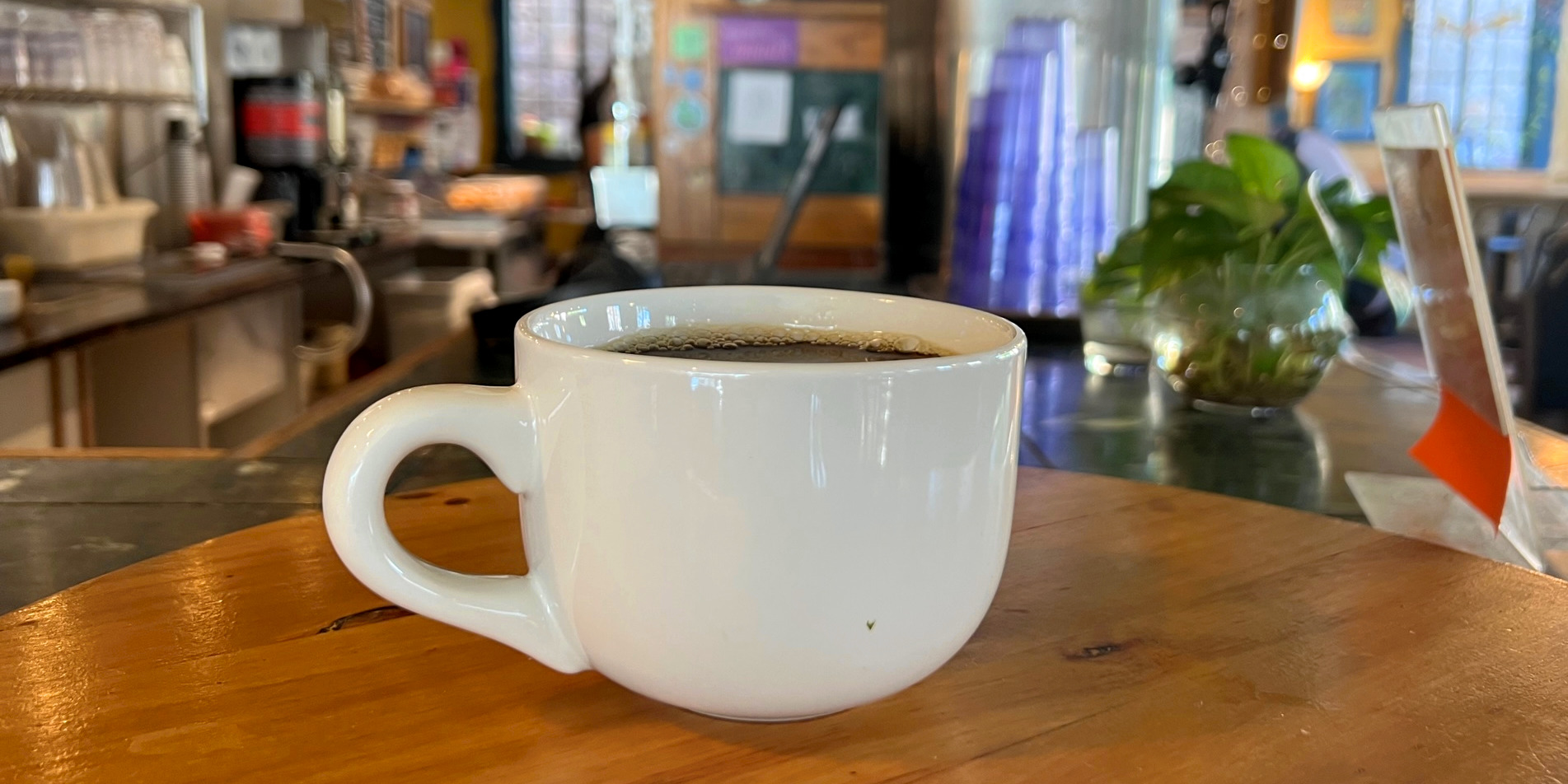 A white mug of black coffee inside Caffe Paradiso ready for pick-up.