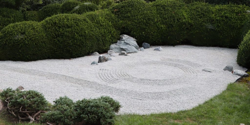 A dry rock garden with a swirled pattern raked into it.