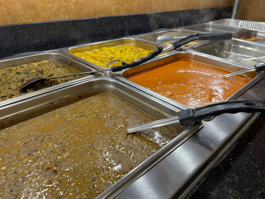 Lentils, veggies, and paneer masala on the buffet line at Ambar India Restaurant.