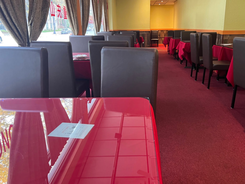 The interior of Chong Qing House in Champaign has red-tableclothed tables with cushy burgundy chairs.