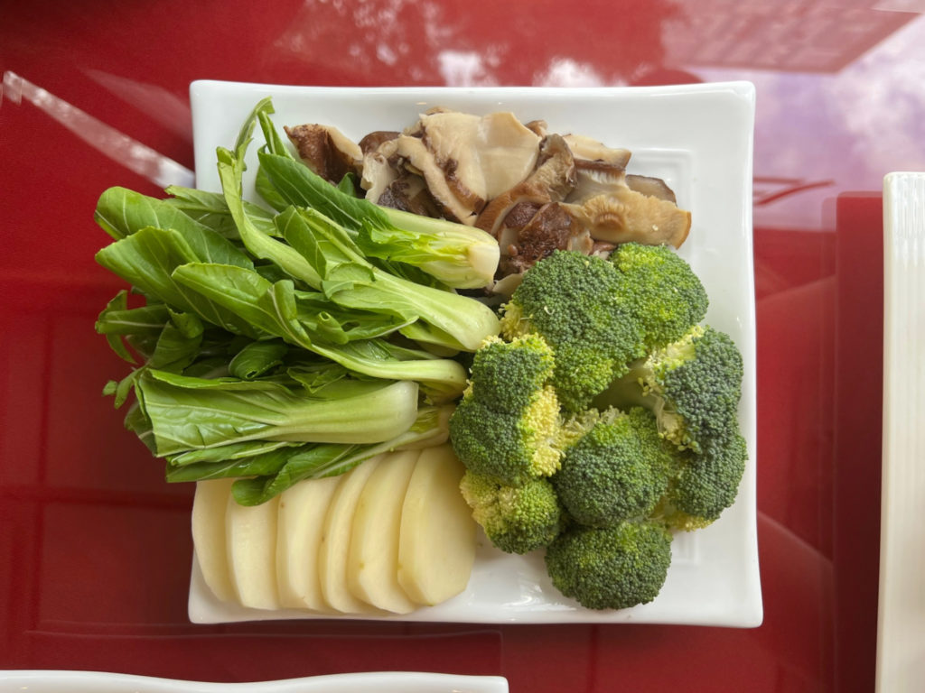 The vegetables for hot pot at Chong Qing House, which are customizable for each order. The author ordered bok choy, mushrooms, potatoes, and broccoli.